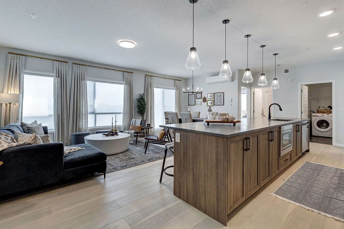 Kitchen with island and stainless appliances at Seton Summit Calgary SE condos for sale